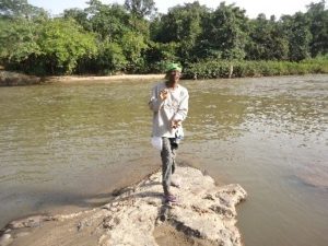 Professor O.O. Oyesiku waiting to cross a river with crocodiles